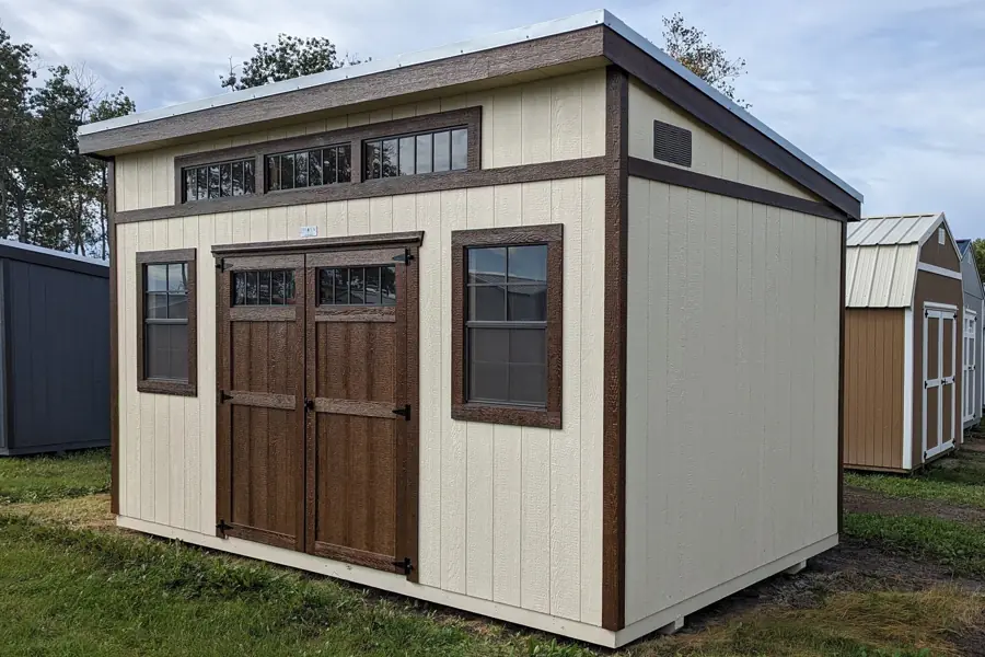 Cream modern high-wall shed with stained double doors and transom windows